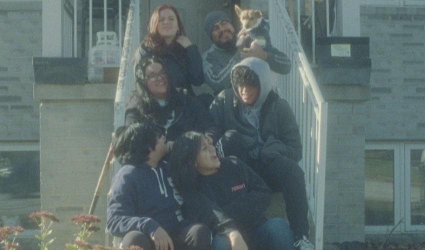 a family sits on the front steps of a house